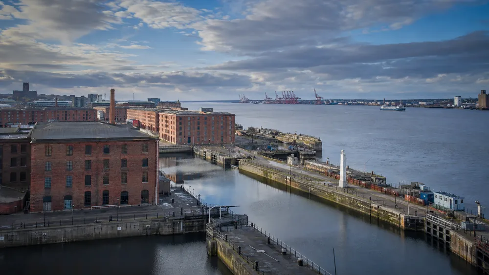 River Mersey waterfront with brick dock buildings and port cranes