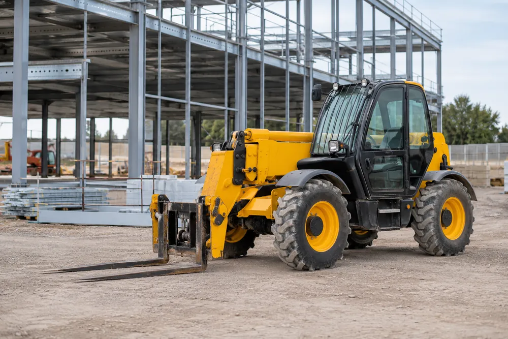 Telehandler with lowered forks at a commercial construction site